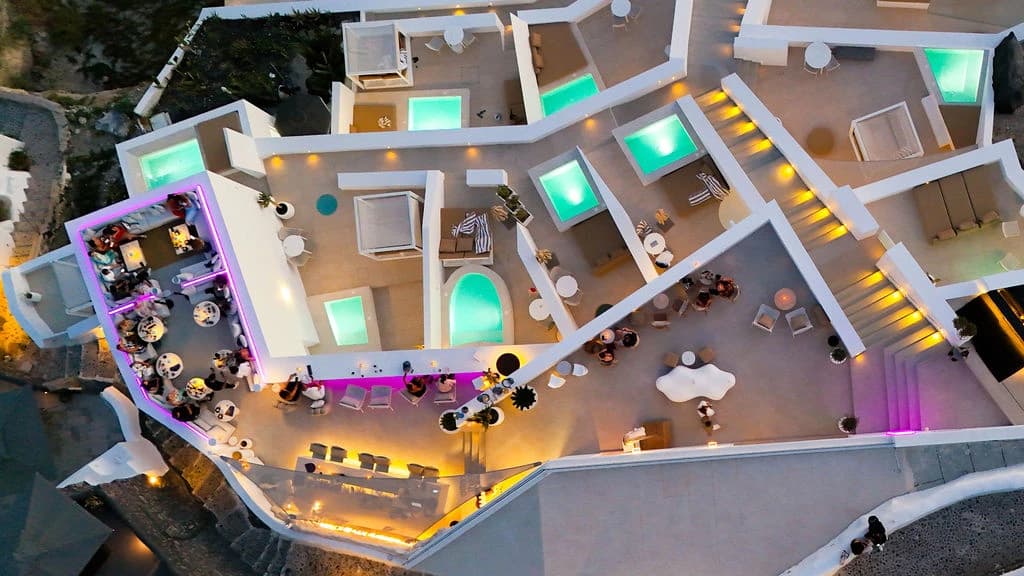 Aerial view of the rooftop at night with the seating areas outlined: 1, the VIP Lounge, the sofa booths at the head of the L-shaped cliff lounge; 2, the Non-smoking tables, the tables down its long arm; 3, the Smoking tables, along the magenta-lit caldera ledge. The bar counter and the upper deck are outside this view. All seating is outdoor.